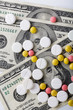 © stas_malyarevsky - Medicine pills or capsules, vitamin with money, dollar. Medical or pharmacy prescription for health. Business, finance concept. Cost of the healthy life. Money and pharmacy still life