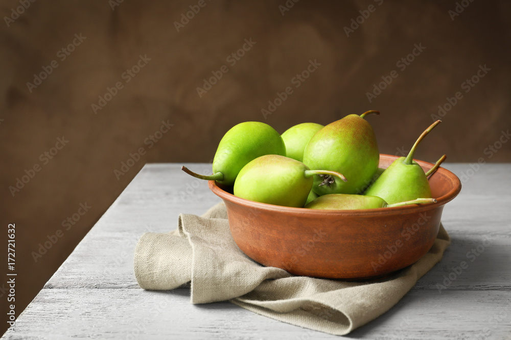 Bowl with delicious ripe pears on table