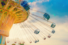 Carousel Ride Spins Fast In The Air At Sunset - A Swinging Carousel Fair Ride At Dusk
