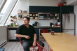© Rob and Julia Campbell/Stocksy - Portrait of young man sitting at table thinking