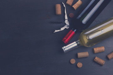 Bottles of red and white wine with corks on table, retro toned