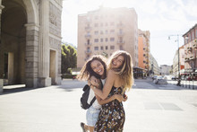 Two Smiling Girls Having Fun Together In The City