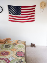 American Flag And Straw Hat Hanging On Wall Of Bedroom