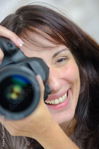 Photographie  young businesswoman holding a professional dslr camera