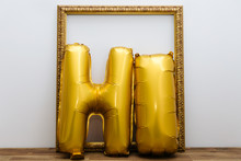 Gold Balloons That Spell The Word "HI" With Gold Picture Frame - Horizontal