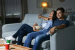 © Africa Studio - Young couple watching TV in evening at home