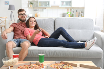 Wall Mural - Young couple watching TV at home