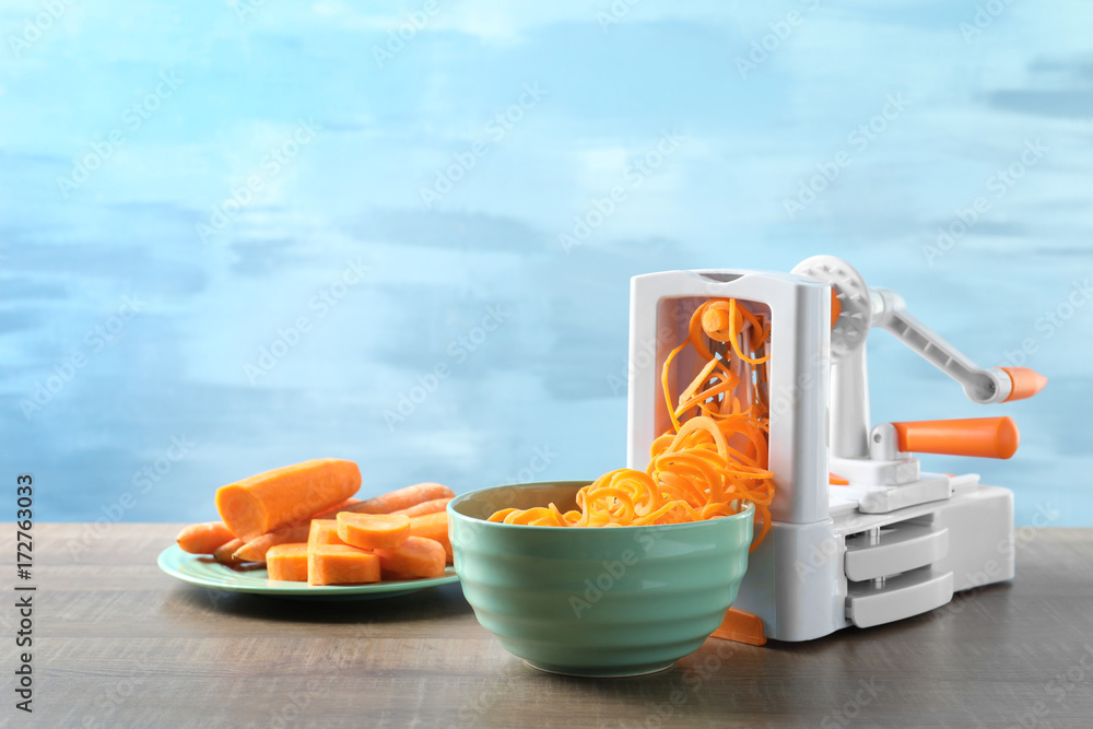 Spiral vegetable slicer with carrot spaghetti on table