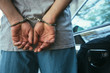 © catklein/Stocksy - Man in handcuffs next to his car