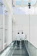 © MyMicrostock/Stocksy - Doctors Walking Through a Modern Hospital Corridor