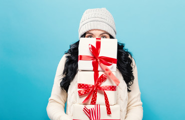 Happy young woman holding a stack of gift boxes