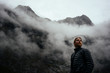 © Christian McLeod Photography/Stocksy - Man in his down jacket looking towards the cold foggy sky as the weather changes