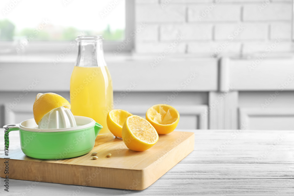 Composition with lemon squeezer on table in kitchen