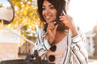 © Drobot Dean - Close-up image of happy african woman sitting on modern motorbike