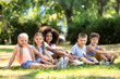 © Africa Studio - Group of children sitting on grass in park