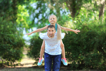 Wall Mural - Young man playing with little girl in park