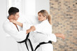 © Africa Studio - Young man and woman practicing karate in dojo