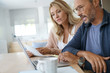 © goodluz - Mature couple at home working on laptop computer
