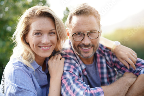 Portrait of mature couple relaxing in outdoor sofa Poster Mural XXL