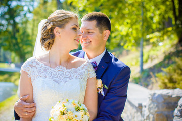 Wedding beautiful couple with good mood kisses on a nature. Love is all you need. Plus size tenderness bride and younger groom