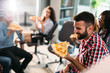 © NDABCREATIVITY - Software enginneers sharing pizza on break from work