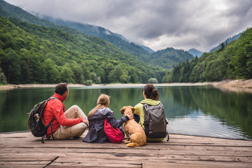 family with dog resting on a pier