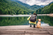 Woman with a dog standing on pier by the lake