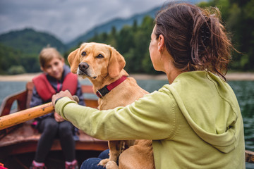 mother and daughter with a dog rowing a boat