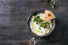 Labneh Middle Eastern Lebanese Cream Cheese Dip With Olive Oil, Salt, Herbs Served Traditional Pita Bread In Terracotta Bowl Over Dark Texture Metal Background. Top View With Space