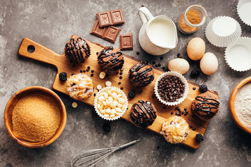 Baking ingredients and homemade muffins with chocolate and berries, selective focus.