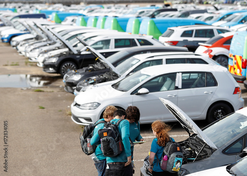 Greenpeace Volunteers Stand Next To A Line Of Cars With Their