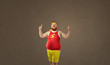 © Studio Romantic - Fat funny freak man in sports clothes points with his finger up.