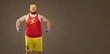 © Studio Romantic - A funny bearded fat man smiles in sports clothes with small dumbbells.