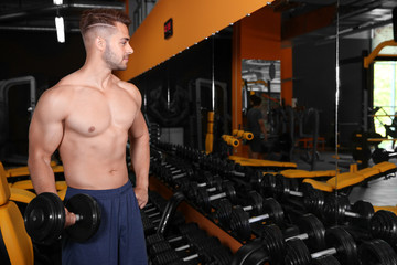 Sticker - Sporty young man doing exercise with dumbbell in gym