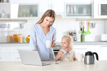 Wall Mural - Busy young woman with her daughter at home