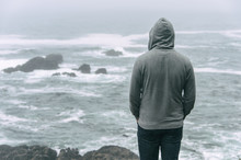 Man Standing In Front Of The Pacific Ocean And Looking At The Stormy Sea On Vancouver Island.