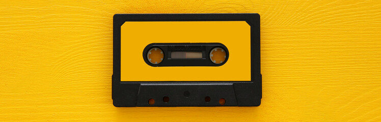 Wall Mural - Retro cassette tape over yellow wooden table. top view. copy space