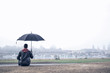 Mann mit Regenschirm bei Nebel