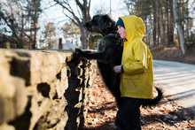 Little Boy Walking His Black Dog