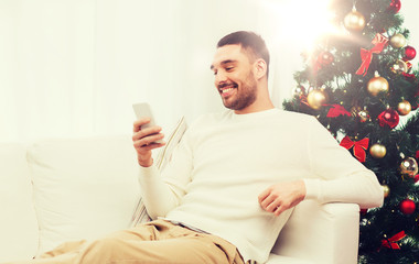 Poster - smiling man with smartphone at home for christmas