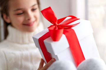 Poster - girl with christmas gift sitting on sill at home