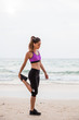 © Jovo Jovanovic/Stocksy - Woman stretching at the beach - fitness outdoors