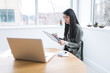 © ZeroThree - Young woman writing on a whiteboard by a laptop