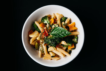 Pasta Primavera on black background, horisontal with negative space