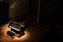 Black Grand Piano At Spot Light In Dark Room