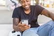 © Westend61 - Smiling young man looking at smartphone, close-up