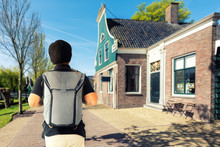 Young Asian Man On European Vacation In Amsterdam With Typical Dutch Stone Houses In Old Small Village Near Amsterdam, Netherlands.