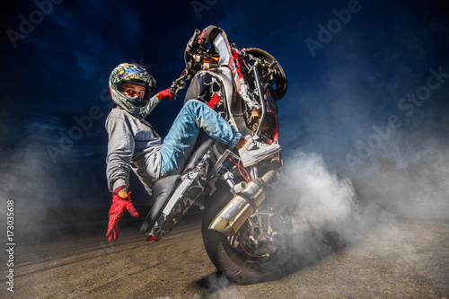 Foto  Moto rider making a stunt on his motorbike