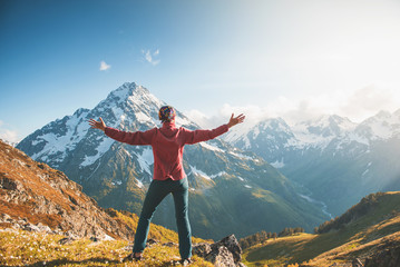 Woman hiker standing on the top of mountain. Back pose