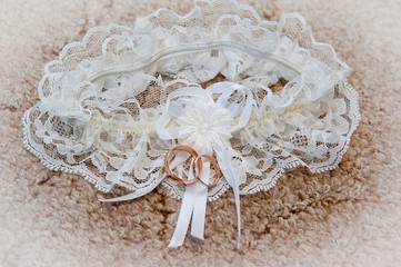 gold wedding rings on a background garters bride in day